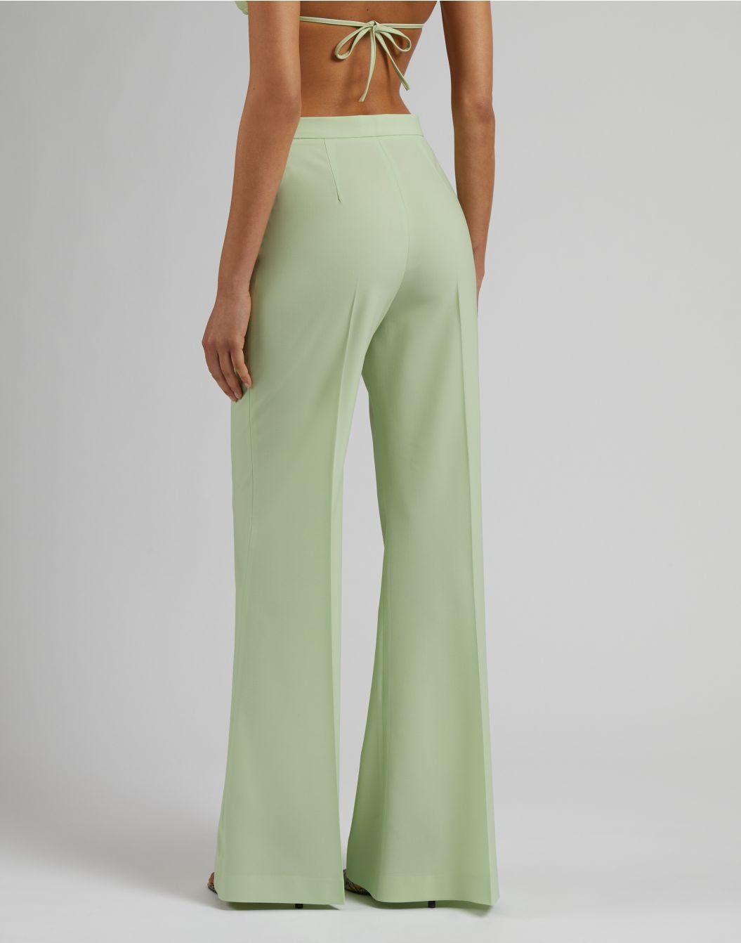 Green high-waisted trousers with a flared hem in stretch wool cloth