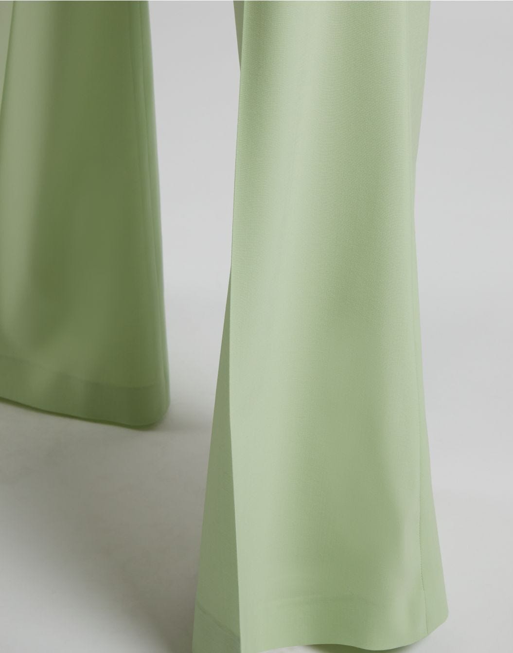 Green high-waisted trousers with a flared hem in stretch wool cloth